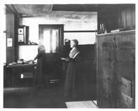SA1324.7b - Four different interiors, showing cupboards, a kitchen with two women, a bench along a wall, and a cabinet with small drawers., Winterthur Shaker Photograph and Post Card Collection 1851 to 1921c